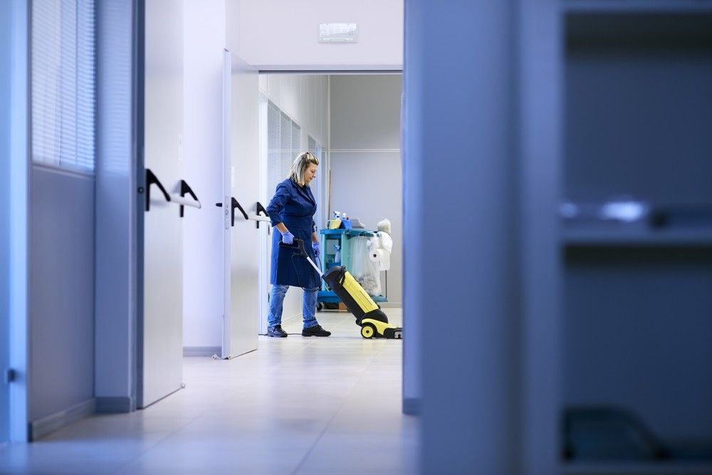 A Woman is Cleaning the Floor of a Building With a Mop — Verdi Cleaning Services in Gungahlin, ACT