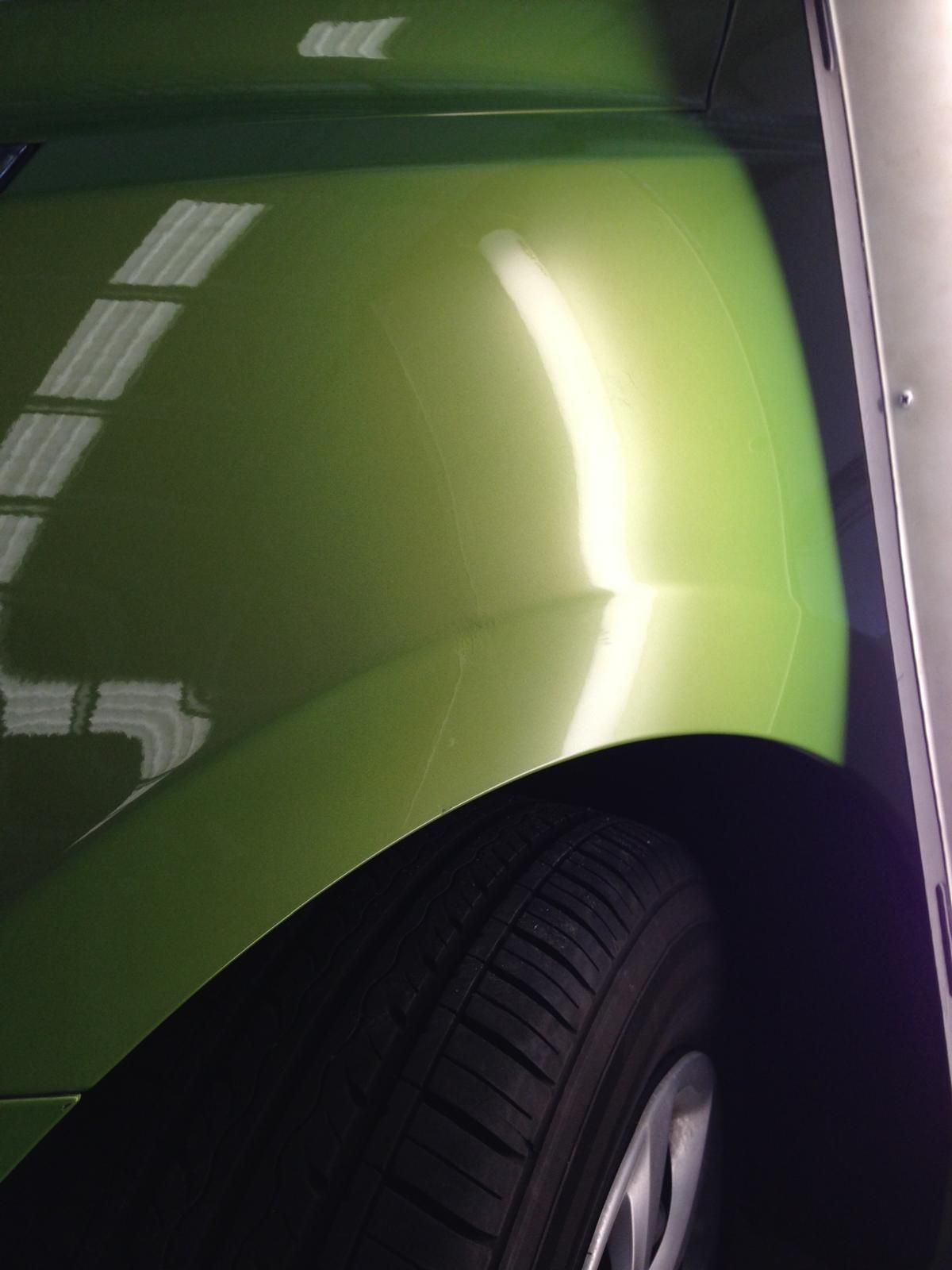 Silver car's wheel well after repair, showing smooth paint and no damage.