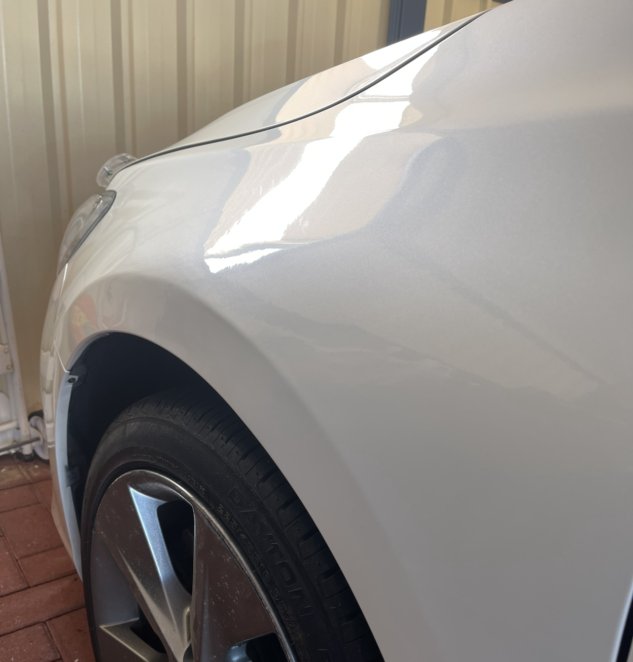 White car fender and tire with shiny paint.