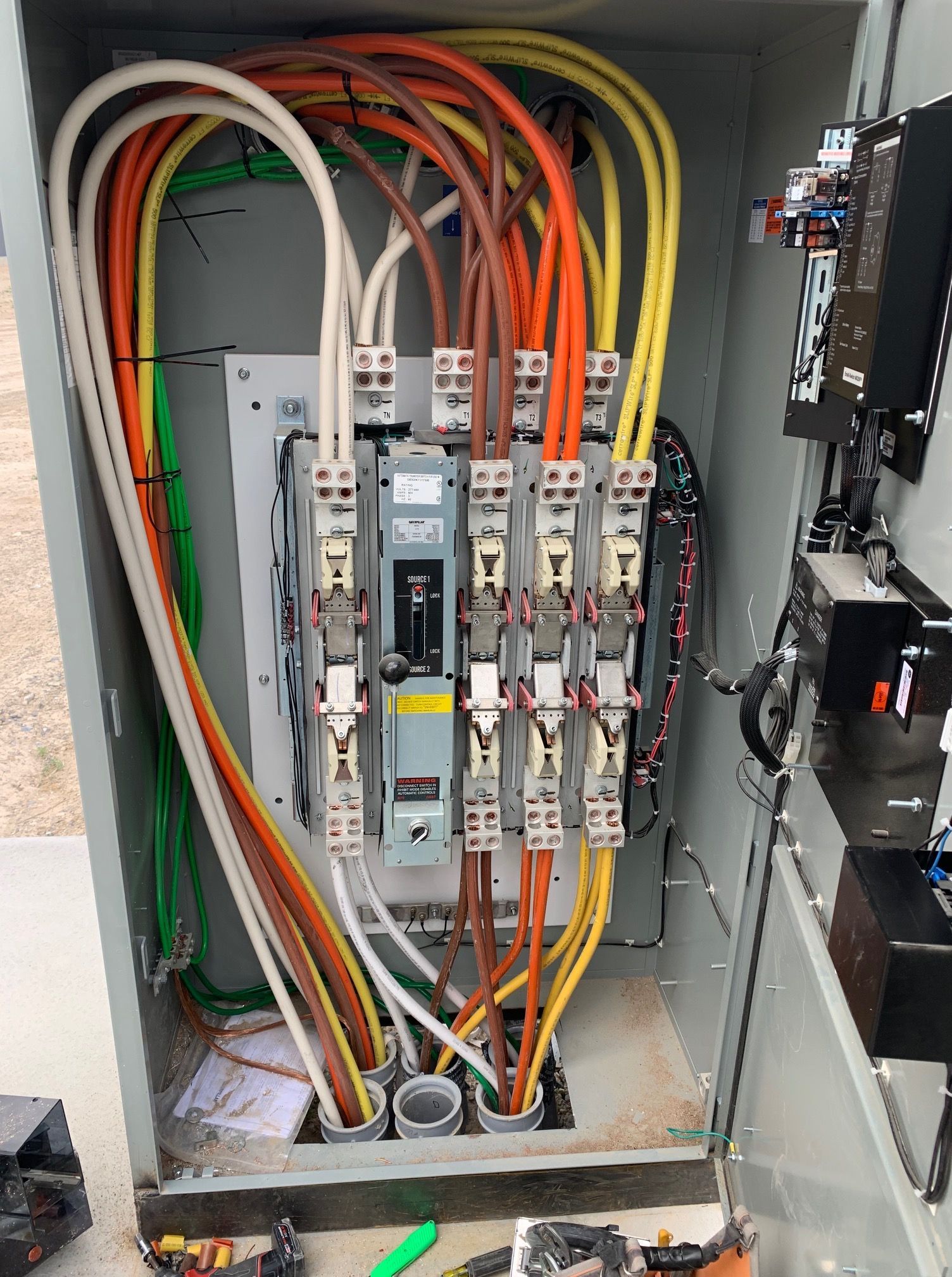 Electrical panel with colored wires connected to circuit breakers.