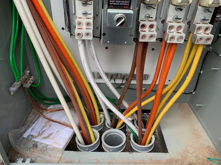 Electrical panel with colored wires connected to terminals.