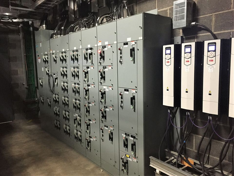 Hands of electrician installing wires in a circuit breaker panel.