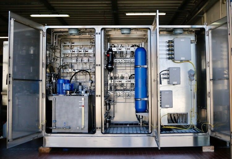 Open stainless steel cabinet with complex machinery, including a blue cylinder and electrical components.