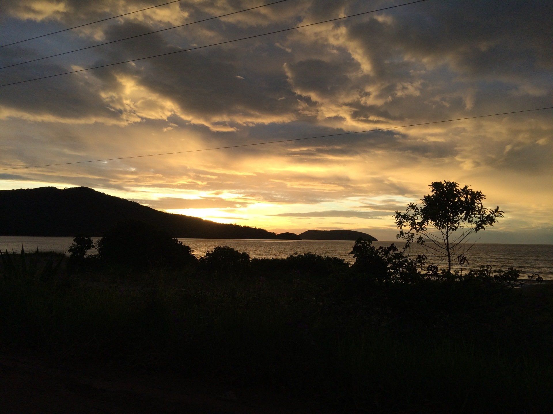 A sunset over a body of water with mountains in the background
