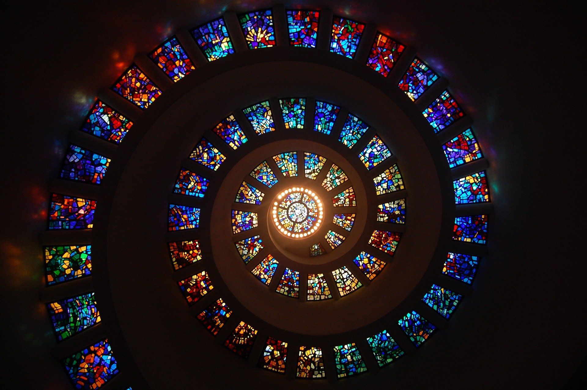 Looking up at a spiral of stained glass windows