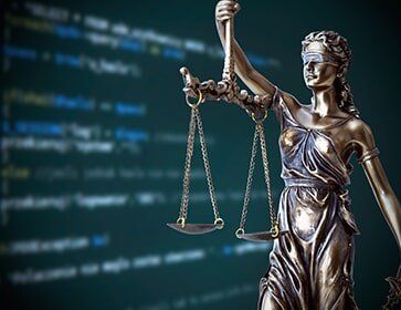 Code on screen with Justice Statue - Law Services in New Brunswick, NJ