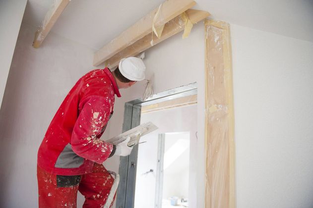 a man is standing on a ladder painting a wall