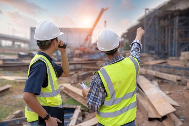 two construction workers are looking at a construction site