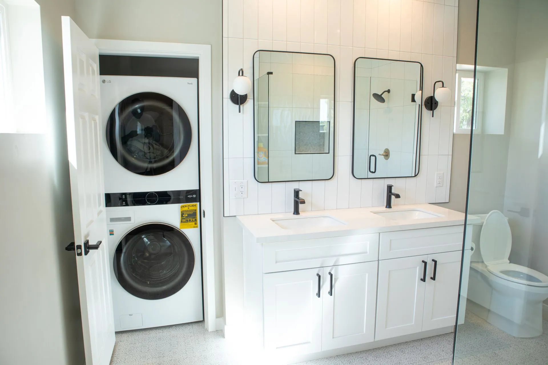 A bathroom with a washer and dryer stacked on top of each other.