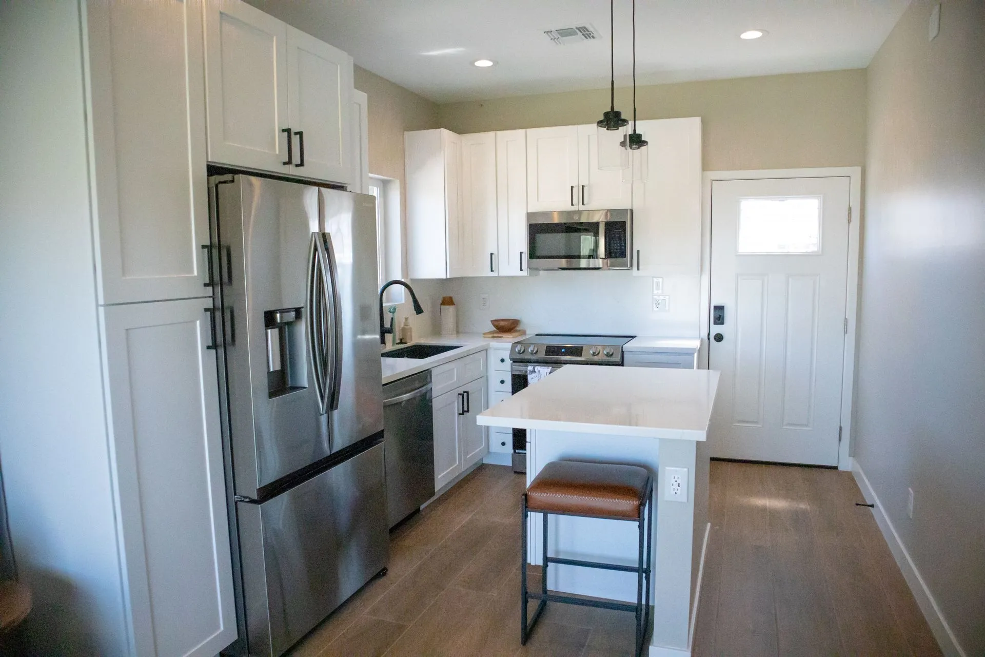 A kitchen with stainless steel appliances and white cabinets