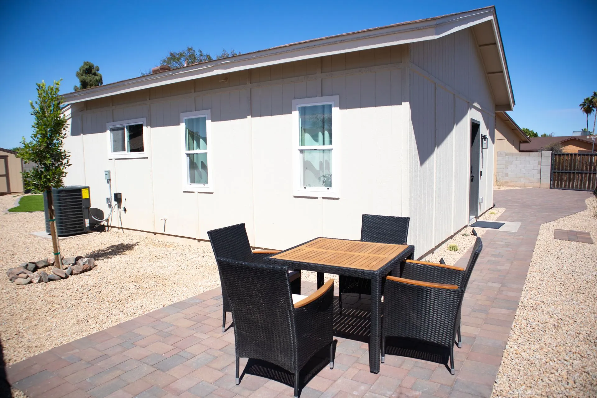 A small white house with a table and chairs in front of it.