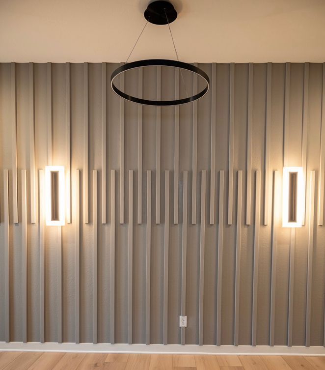 A room with a gray wall and a ceiling light