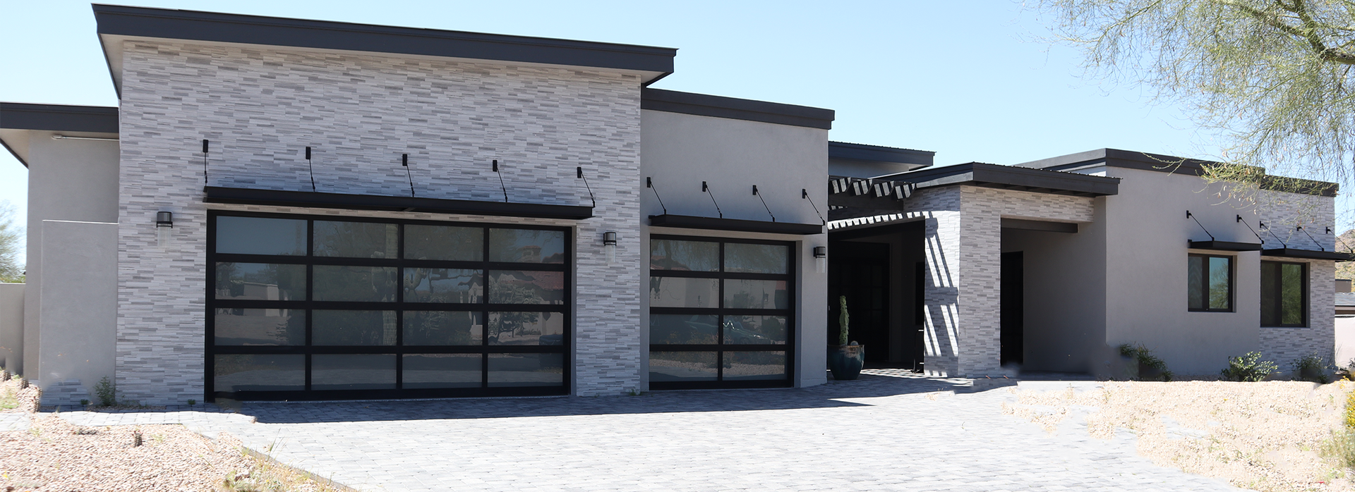 A modern house with two garage doors and a driveway.