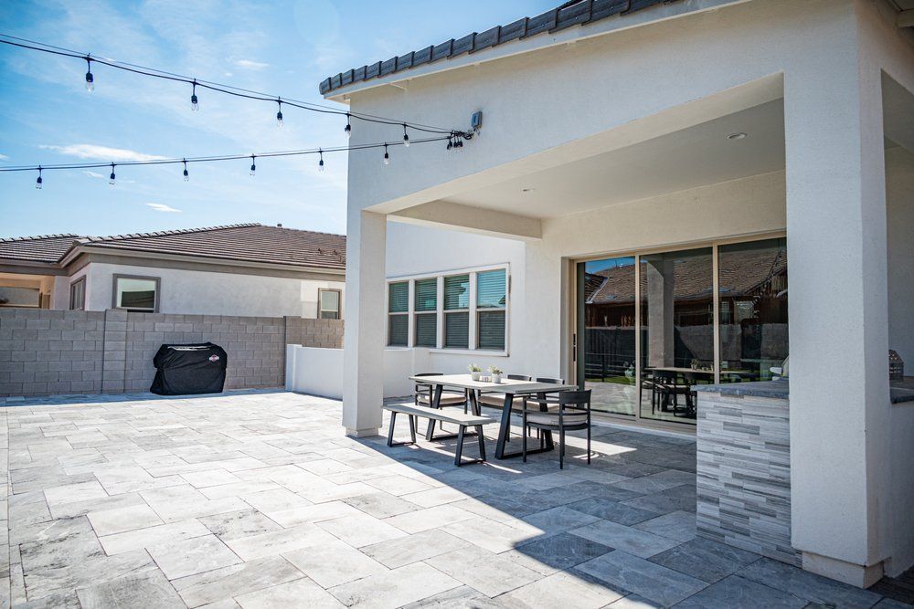 There is a patio with a table and chairs on it.