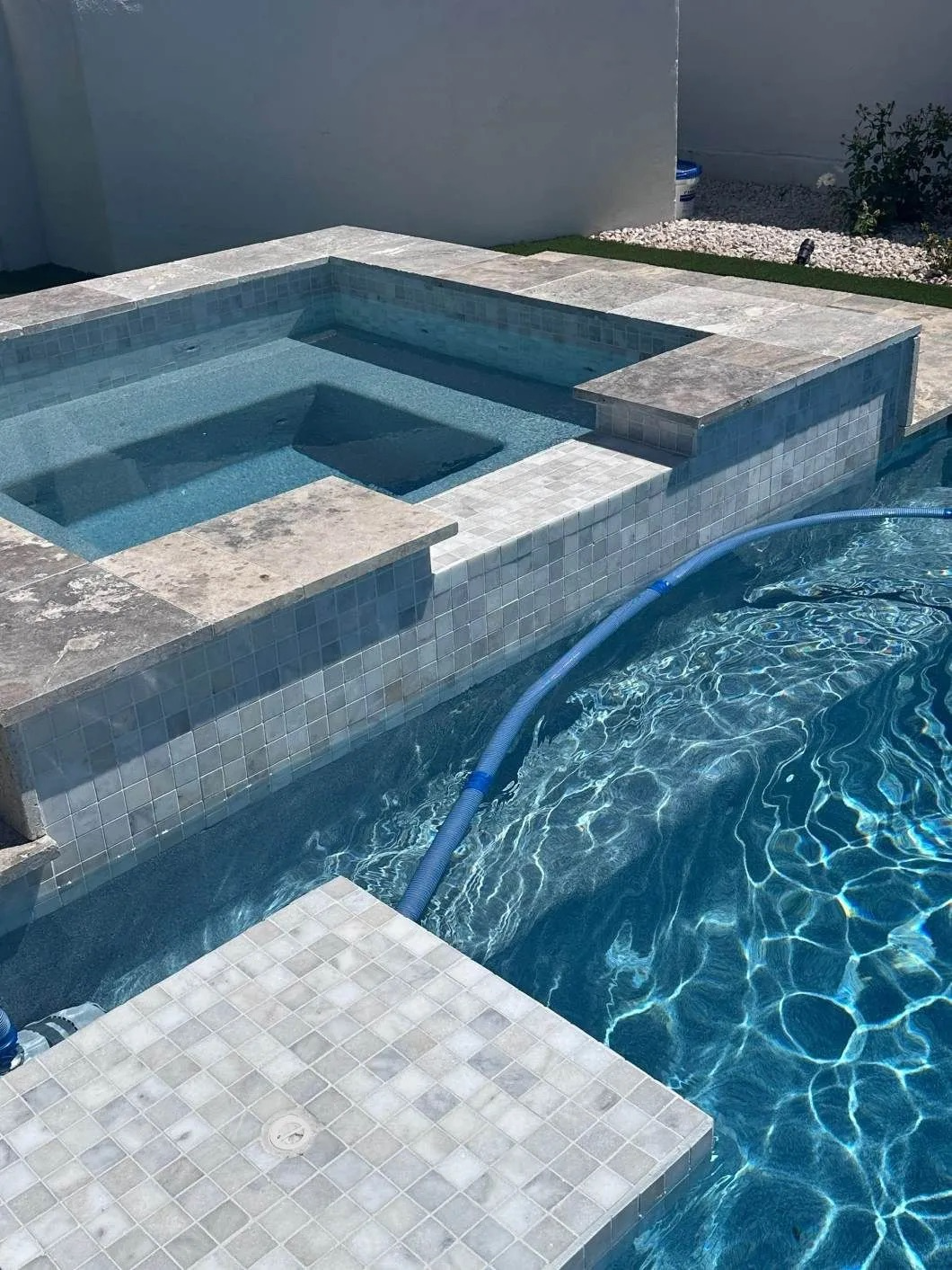 A swimming pool with a hot tub in the middle of it.