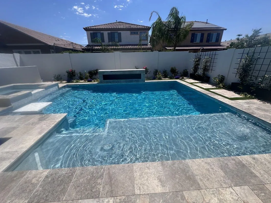 There is a large swimming pool in the backyard of a house.