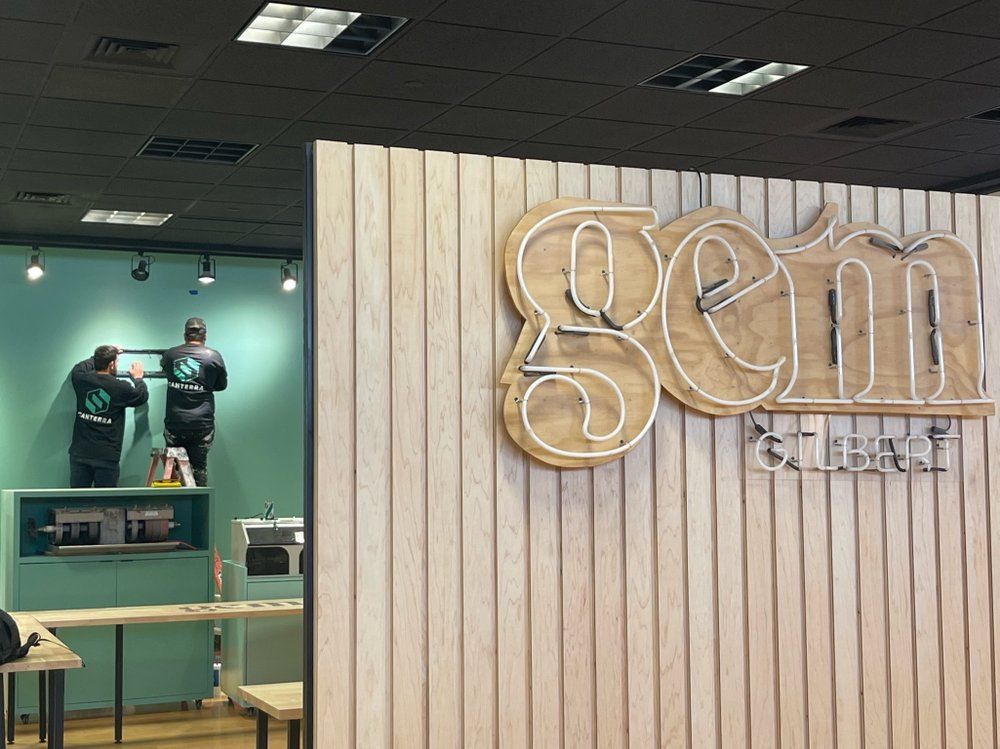 A couple of people are standing in front of a sign that says gem.