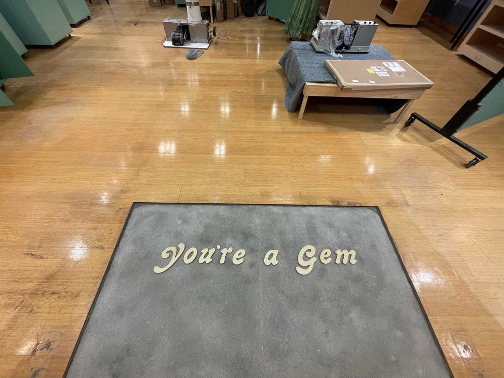A wooden floor with a rug that says you 're a gem