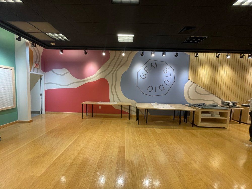 A large room with wooden floors and a clock on the wall