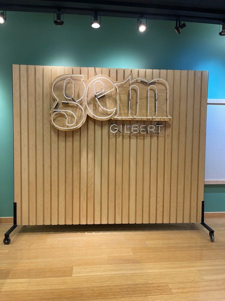 A wooden wall with a neon sign on it.