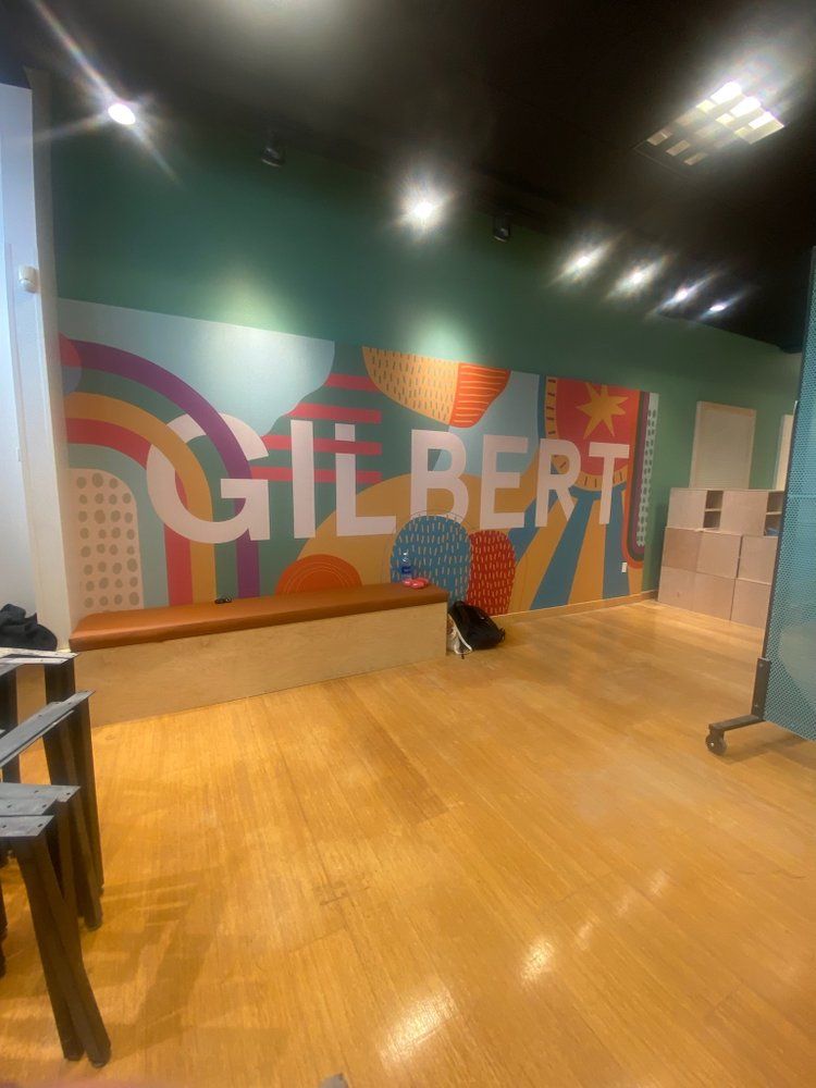 A room with a mural on the wall that says gilbert
