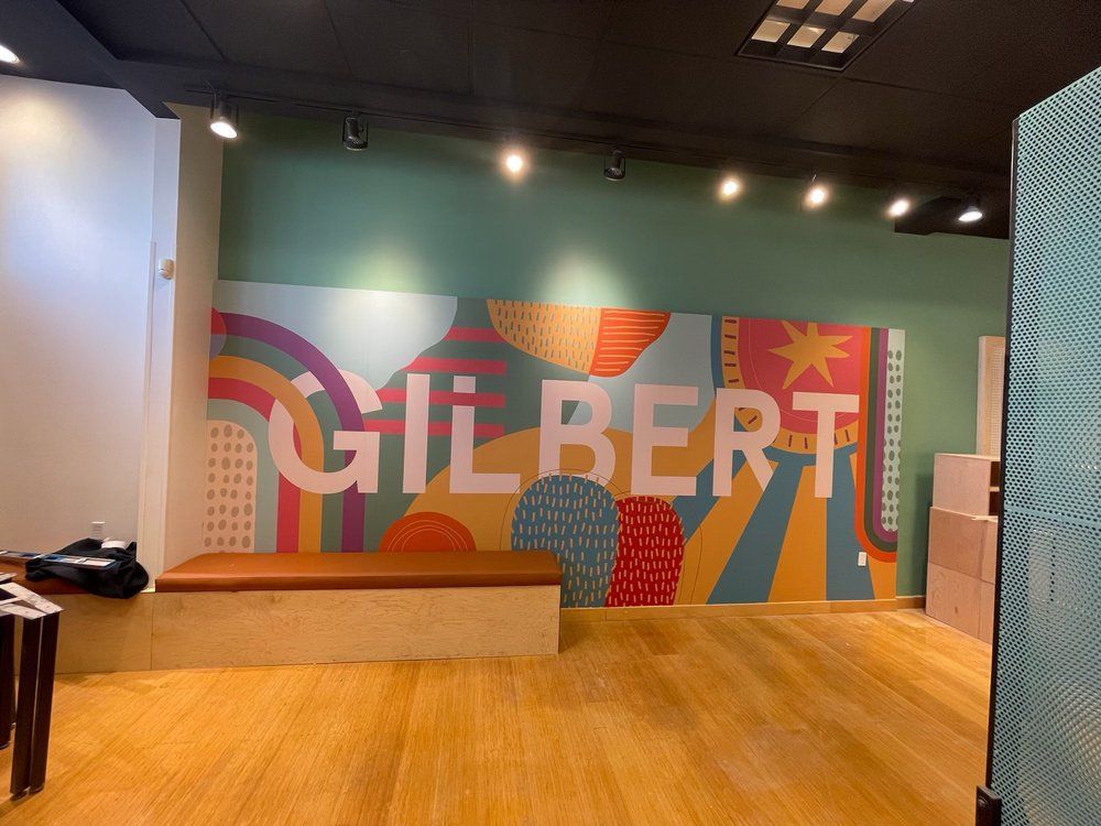 A room with a mural on the wall that says gilbert