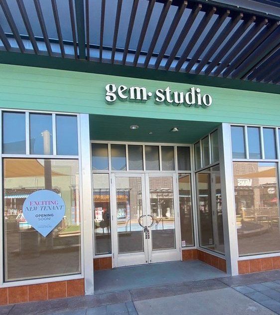 A green building with the word gem studio on it