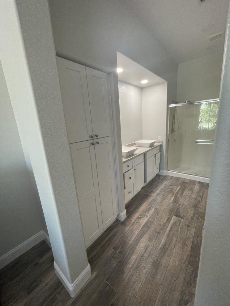 A bathroom with two sinks and a walk in shower.