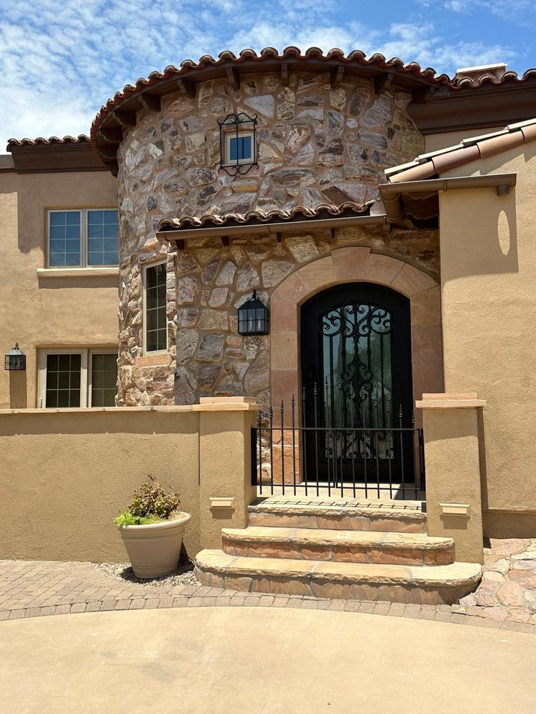 A large stone house with a black door and stairs