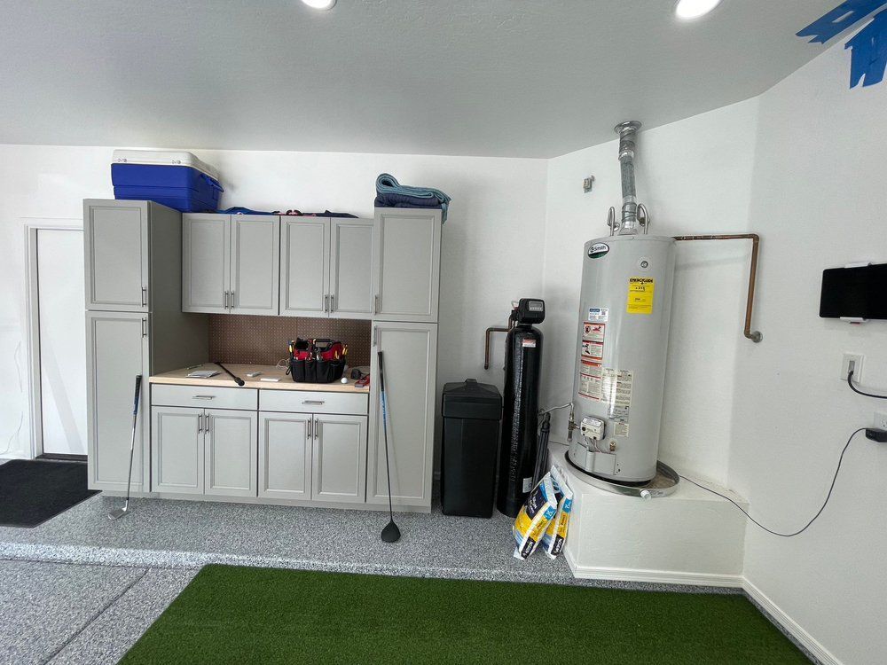 There is a water heater in the middle of the garage.