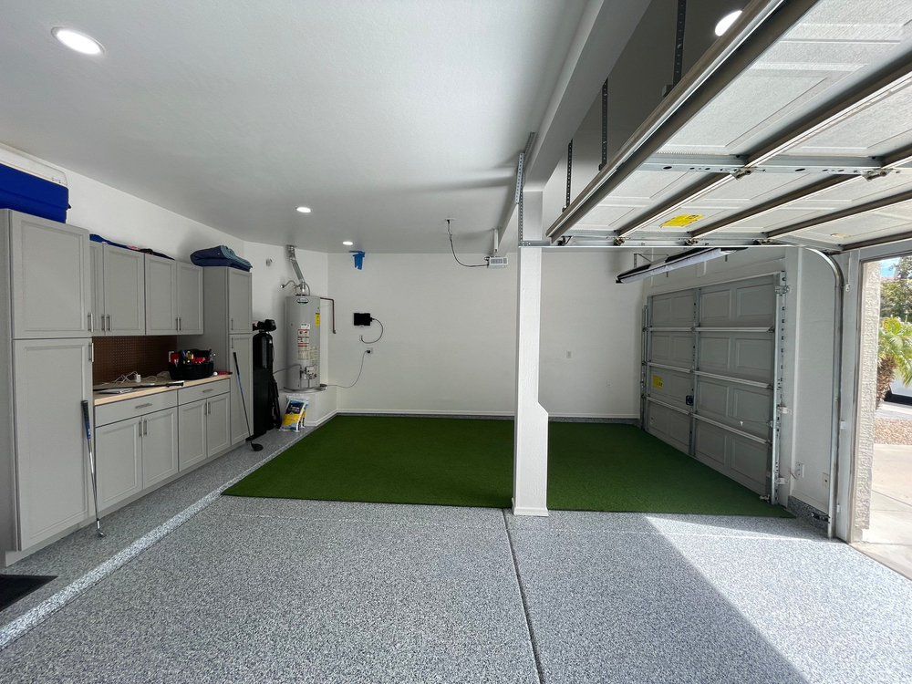 A garage with a synthetic grass floor and a kitchen.