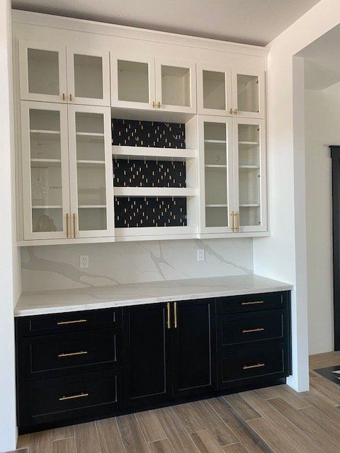 A kitchen with black cabinets and white counter tops