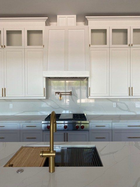 A kitchen with white cabinets and a sink