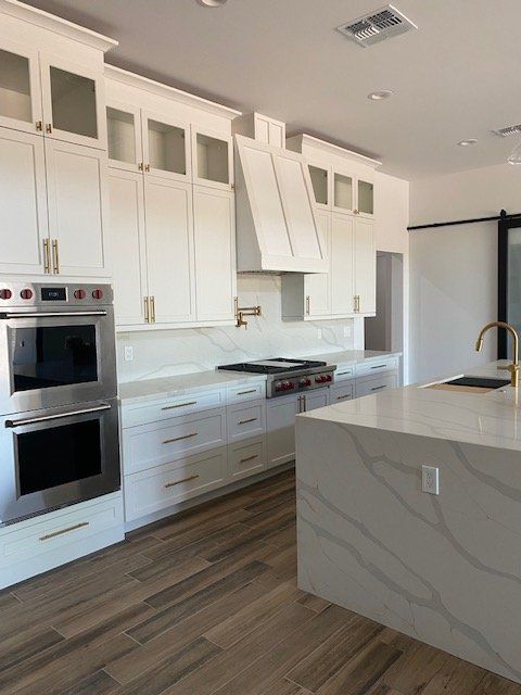 A kitchen with white cabinets and stainless steel appliances