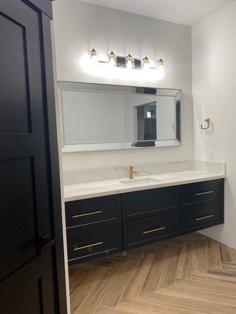 A bathroom with two sinks and a large mirror.