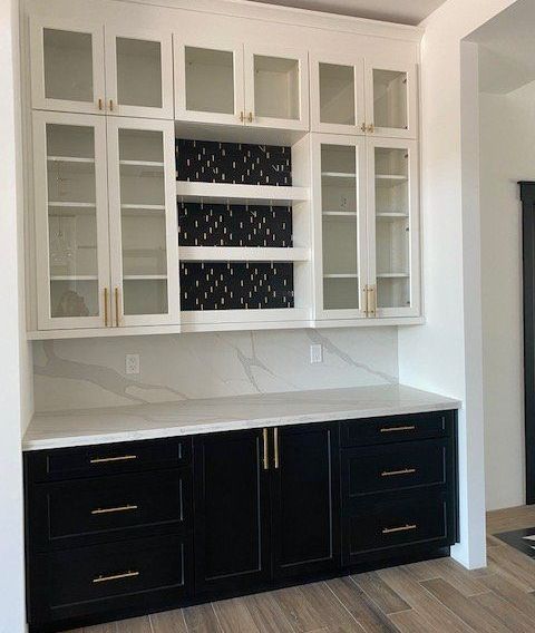 A kitchen with black cabinets and white counter tops