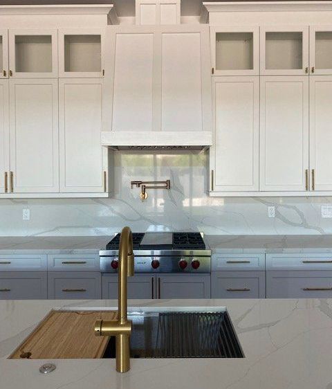A kitchen with white cabinets and a sink