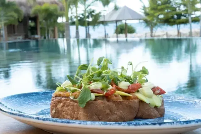 Bruschetta fresca con vegetales y hierbas servida en el restaurante del Hotel Aimarawa Punta Bolívar San Antero, experiencia gastronómica frente a la piscina y el mar.