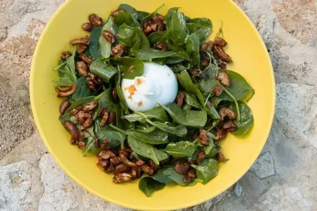 Ensalada fresca con burrata, espinaca y nueces caramelizadas servida en el restaurante del Hotel Aimarawa Punta Bolívar San Antero, gastronomía saludable frente al mar.