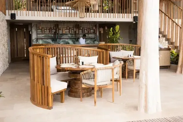 Restaurante exclusivo del Hotel Aimarawa en San Antero con mesas circulares de madera, diseño contemporáneo y ambiente ideal para experiencias gastronómicas en el Caribe colombiano.