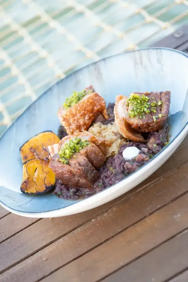 Plato de comida típica colombiana con cerdo crocante y plátano maduro en restaurante del Hotel Aimarawa San Antero.