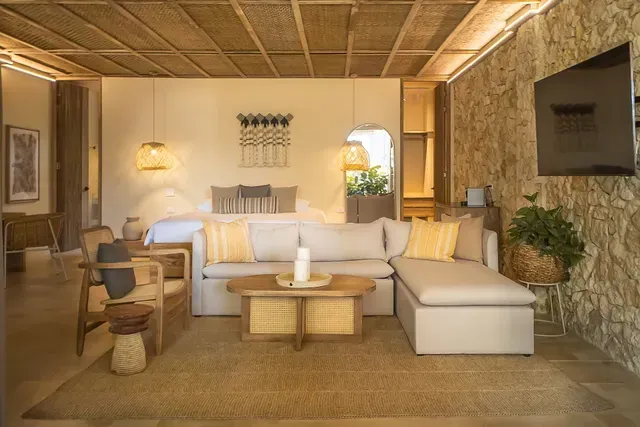 Sala de suite del Hotel Aimarawa en Punta Bolívar con sofá amplio, decoración natural en tonos cálidos y detalles en madera.