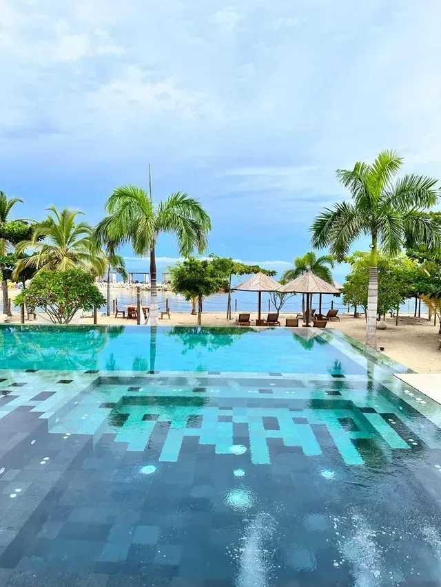 Piscina de hotel en san antero frente al mar, rodeada de palmeras y parte de la experiencia de hoteles en la playa
