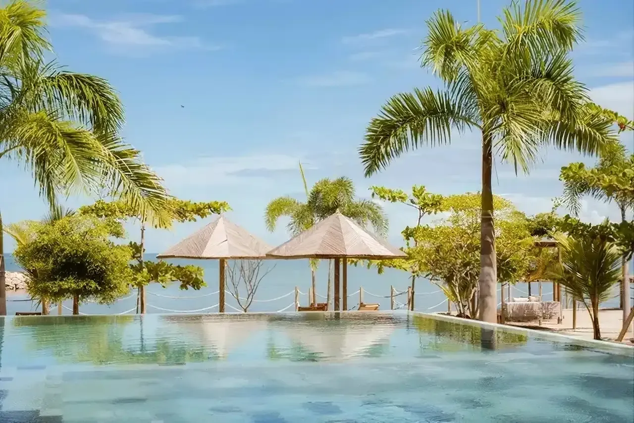 Piscina con vista abierta al mar en hoteles en la playa en Colombia, entorno tranquilo rodeado de palmeras en punta bolívar.
