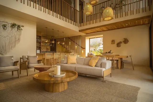 Amplia sala y comedor del hotel Aimarawa en Colombia, con diseño moderno en madera y decoración artesanal ideal para hospedajes de lujo.