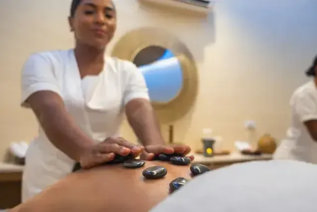 Masaje con piedras volcánicas en el spa del Hotel Aimarawa, experiencia de bienestar y relajación en un eco-lodge de lujo en San Antero, Córdoba.