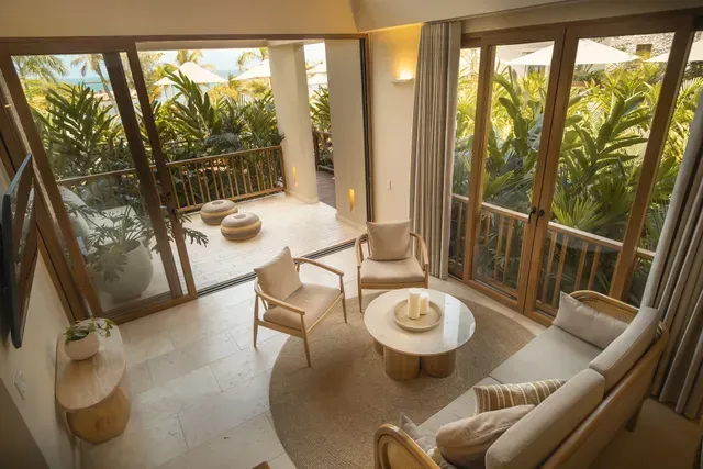 Suite de Aimarawa Palomino con balcón privado y vista a jardines tropicales, diseñada para una experiencia de alojamiento relajante.