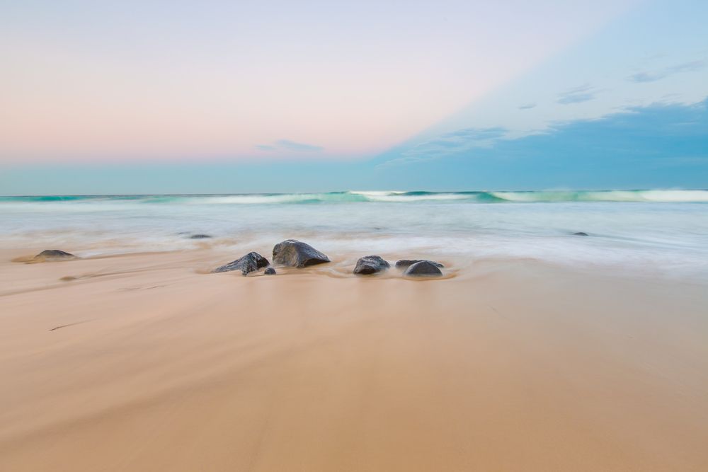 Sandy Beach at Sunset, Dark Rocks, Blue-green Ocean — North Coast Stock Feeds in Ballina, NSW