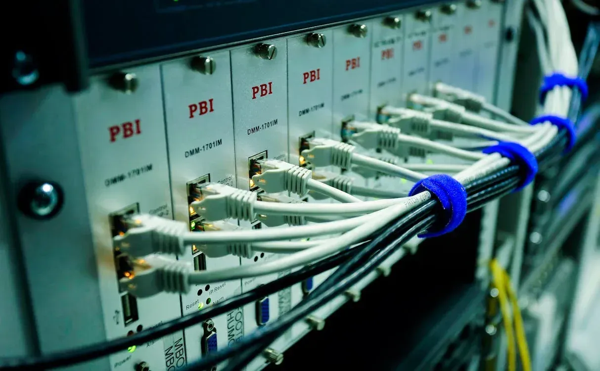A bunch of wires are connected to a server in a server room.