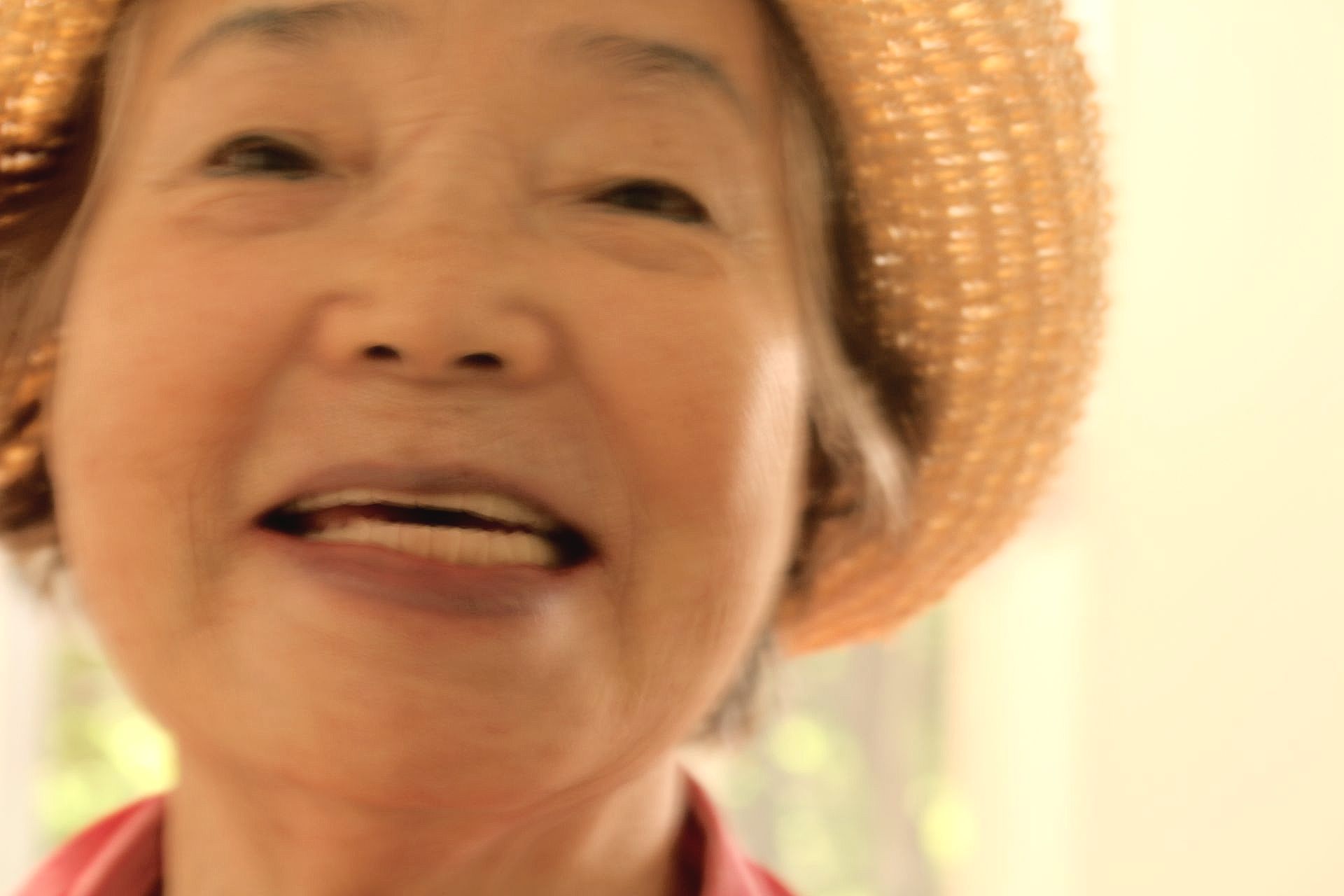a close up of a woman wearing a straw hat